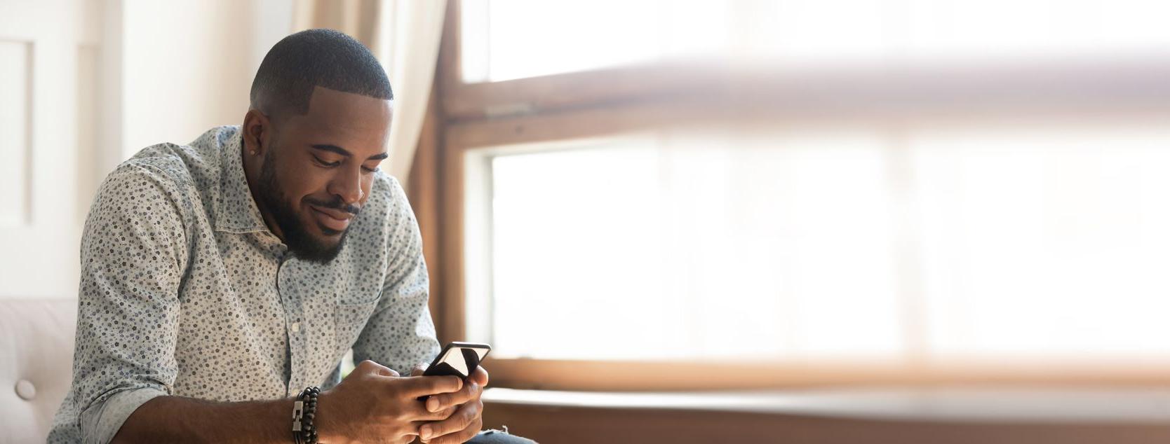 A Patelco member uses his phone to move money between his accounts.